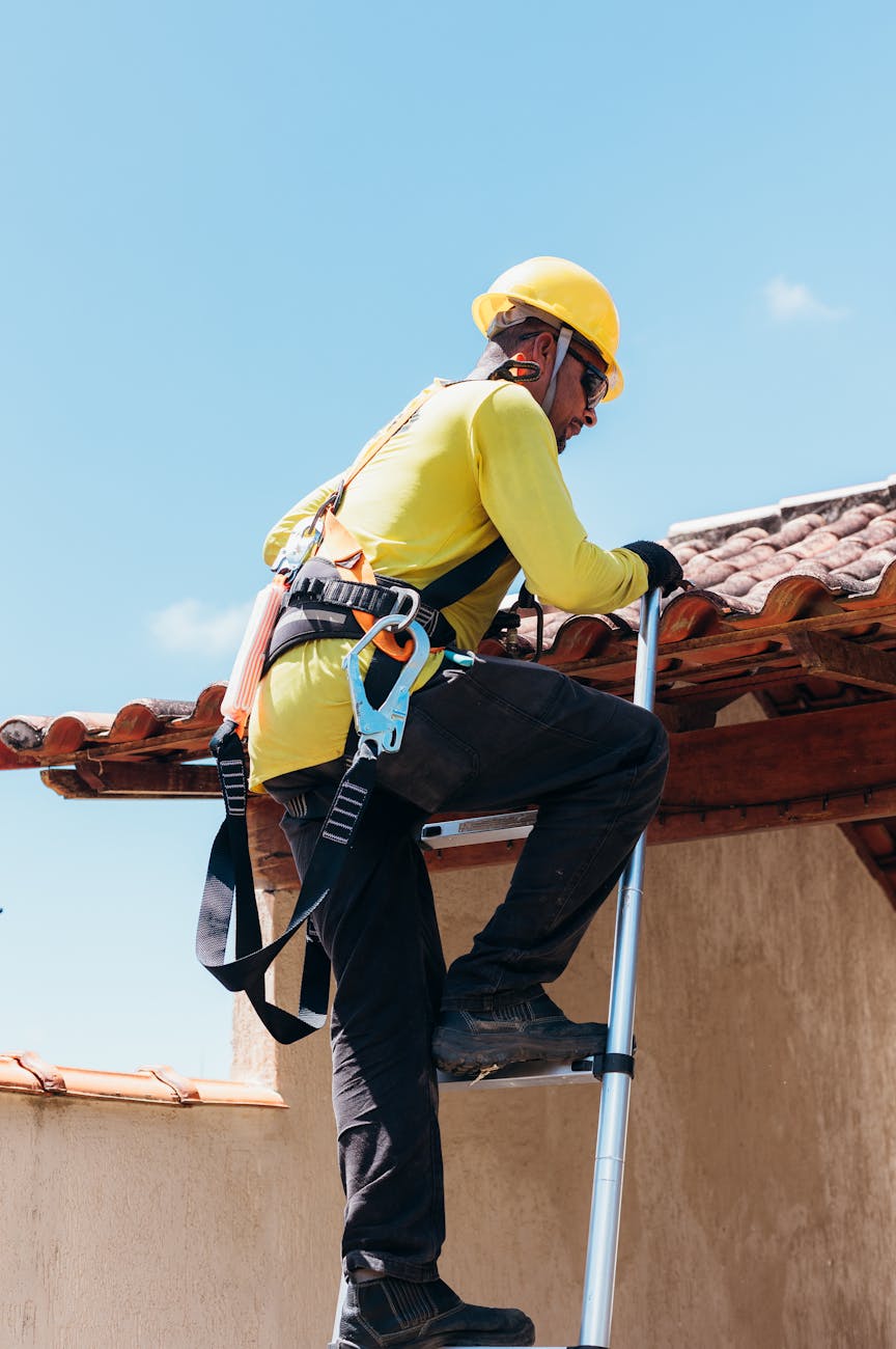 construction worker climbing ladder at worksite